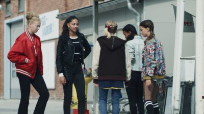 Adja Krook i tv-serien Dröm står och pratar med några personer.
