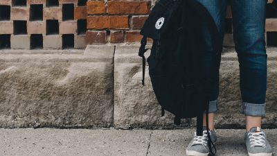 En person håller i en ryggsäck.