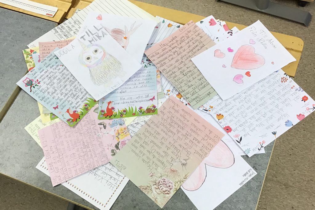 En hög med handskrivna brev som ligger på en bänk.