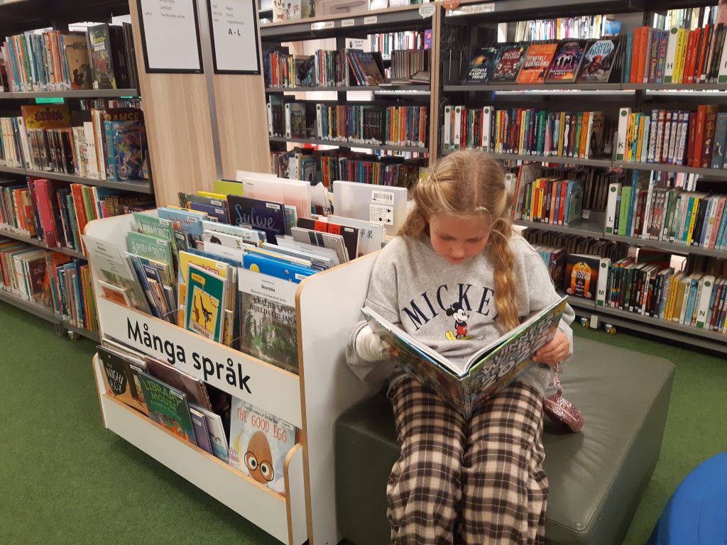 Elsie läser en bok i biblioteket