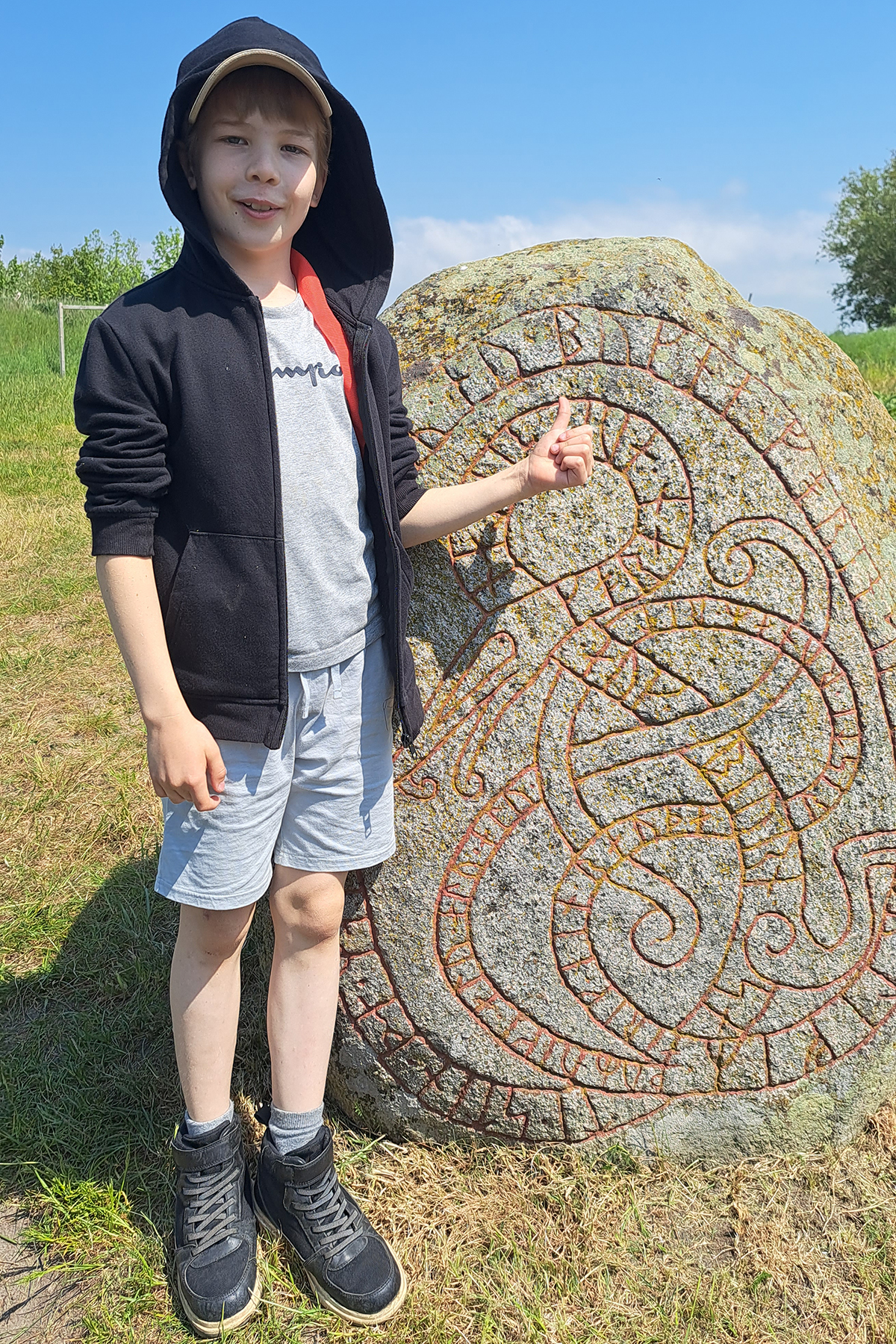 Ludvig framför en runsten.